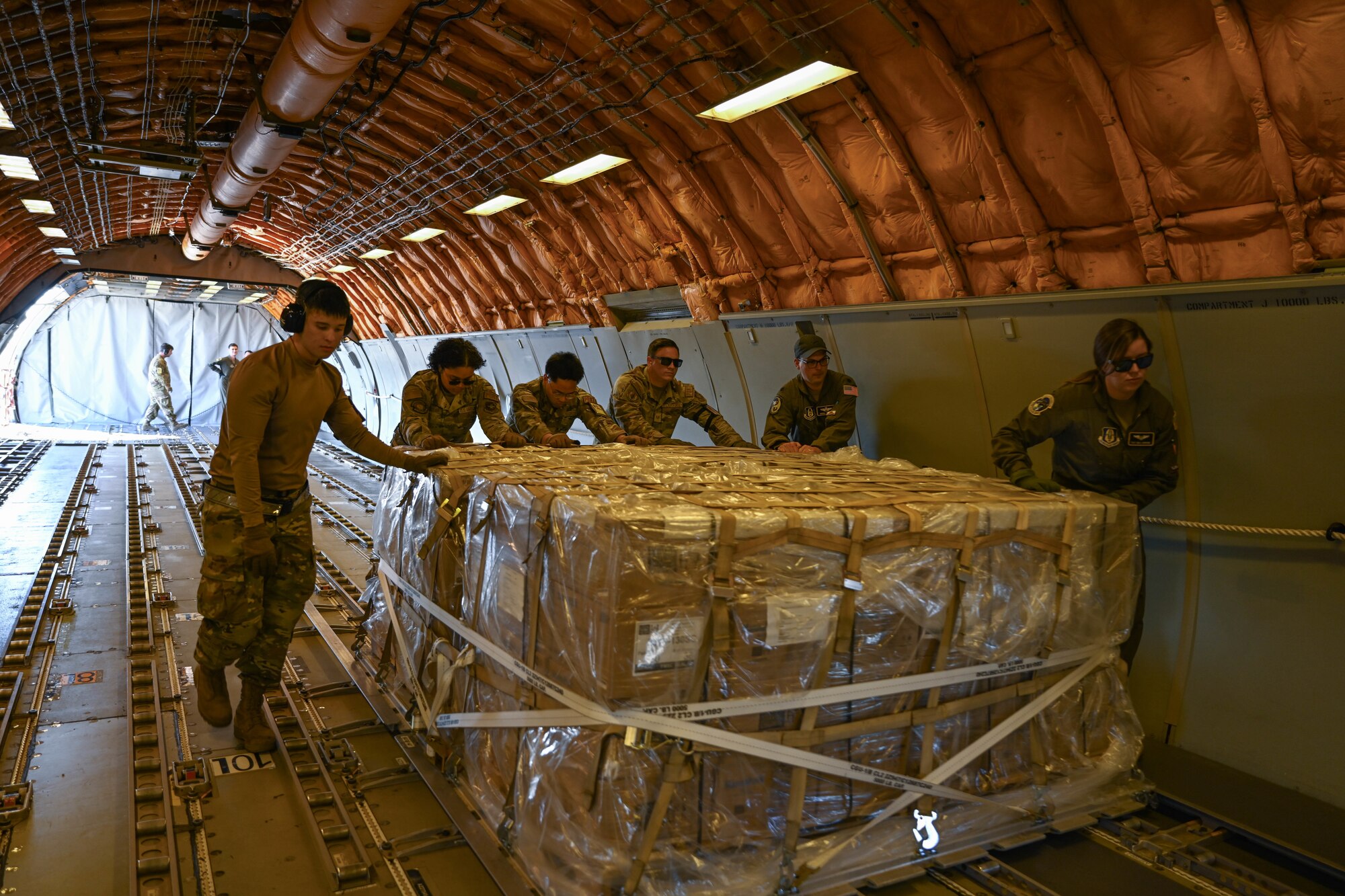 Men in uniform push cargo