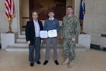 Naval Surface Warfare Center, Carderock Division Commanding Officer Capt. Matthew Tardy (right) pins Naval Architect Patrick Crowley (left) with the Department of Navy Civilian Service Achievement Medal in the Rotunda, Building 2, in West Bethesda, Md., on Jan. 24, 2024. Crowley was honored for his contribution and success with the Expeditionary Fast Transport Unmanned Autonomous Prototype. (U.S. Navy photo by Kristin Behrle)