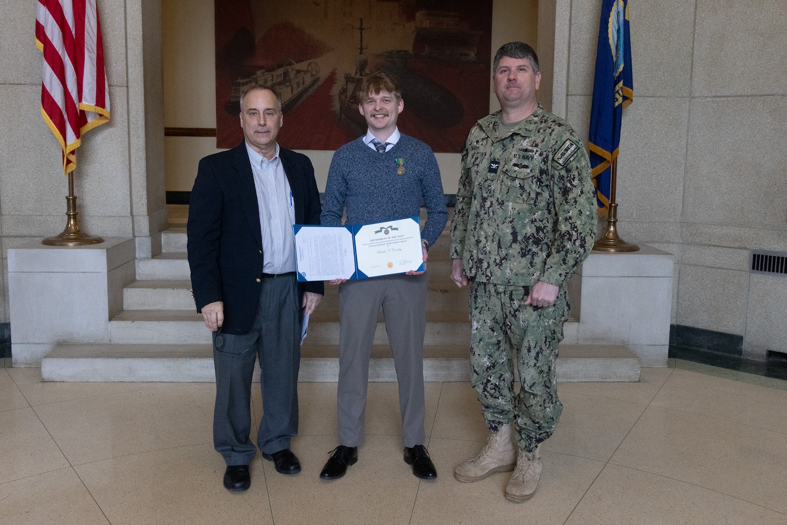 Naval Surface Warfare Center, Carderock Division Commanding Officer Capt. Matthew Tardy (right) pins Naval Architect Patrick Crowley (left) with the Department of Navy Civilian Service Achievement Medal.
