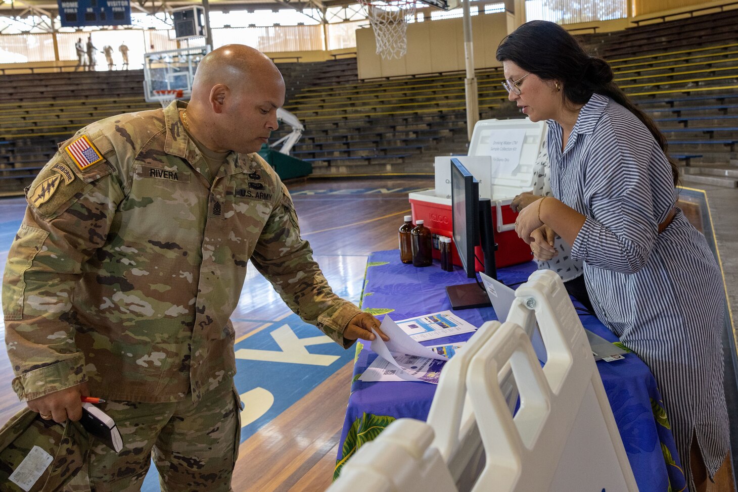 An attendee receives water testing information at a Joint Base Pearl Harbor-Hickam (JBPHH) Command Leadership Town Hall at JBPHH, Feb. 21, 2024. The event was hosted by JBPHH and welcomed command leaders from across the base to hear from Navy leaders working on water quality concerns and the closure of the Red Hill Bulk Fuel Storage Facility (RHBFSF) currently being carried out by Navy Closure Task Force - Red Hill (NCTF-RH). Charged with the safe decommissioning of the Red Hill Bulk Fuel Storage Facility (RHBFSF), NCTF-RH was established by the Department of the Navy as a commitment to the community and the environment. The Navy continues to engage with the people of Hawaii, regulatory agencies, and other stakeholders as NCTF-RH works to safely and deliberately decommission the RHBFSF. (U.S. Navy photo by Mass Communications Specialist Seaman Krystal Diaz)