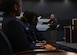 A man stands in front of a room speaking to a row of high school students.