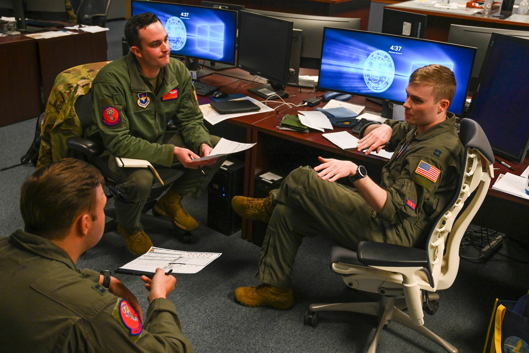 From right to left, U.S. Air Force Capt. Nathan Hartman, 58th Airlift Squadron (AS) instructor pilot, goes over questions from the mission brief with Capt. Andrew Butler, 58th AS instructor pilot, and Capt. Kameron Saranto Mercado, 58th AS instructor pilot, at Joint Base Lewis-McChord, Washington, Feb. 21, 2024. The Airmen participated in mission planning and flew a C-17 Globemaster III during a large formation exercise. (U.S. Air Force photo by Senior Airman Trenton Jancze)