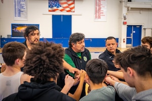 Coaches and students huddle together.