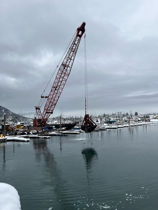 A clamshell dredge hoists shoal from the bottom of Petersburg Borough’s harbor system in southeast Alaska.