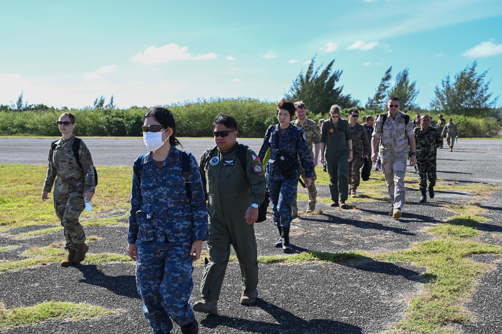 Military members from several countries exit the flightline after arriving on Northfield.