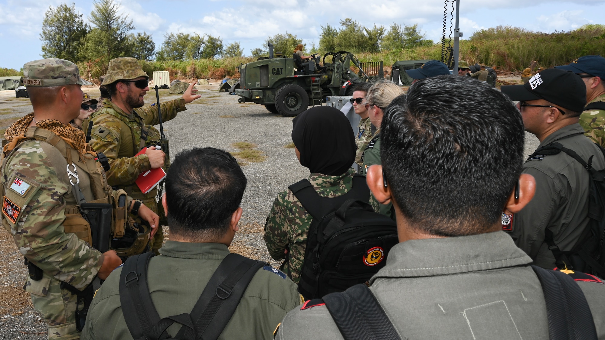 An Airman and an Aviator briefs military members from several countries on how the camp remains operational.