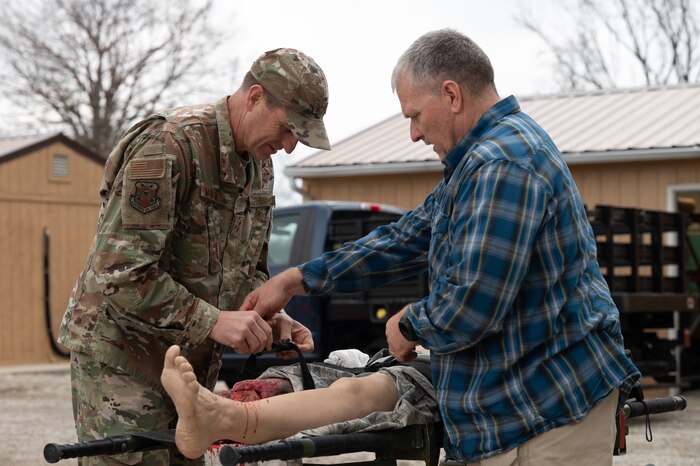 Maj. Gen. Corey Martin applies a tourniquet to a bleeding manikin with the assistance of Clyde Nobles