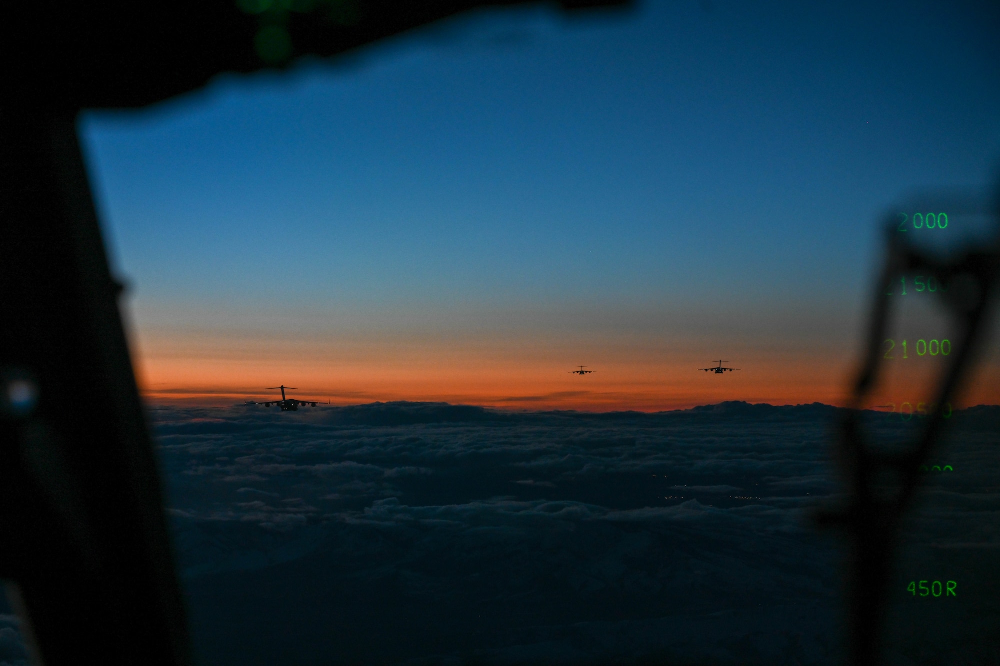 Three C-17 Globemaster IIIs fly during a large formation exercise at Joint Base Lewis-McChord, Washington, Feb. 22, 2024. The exercise served as a platform for pilot and loadmaster instructors from the 58th Airlift Squadron to apply their skills, gaining real-world experience and valuable training. (U.S. Air Force photo by Senior Airman Trenton Jancze)