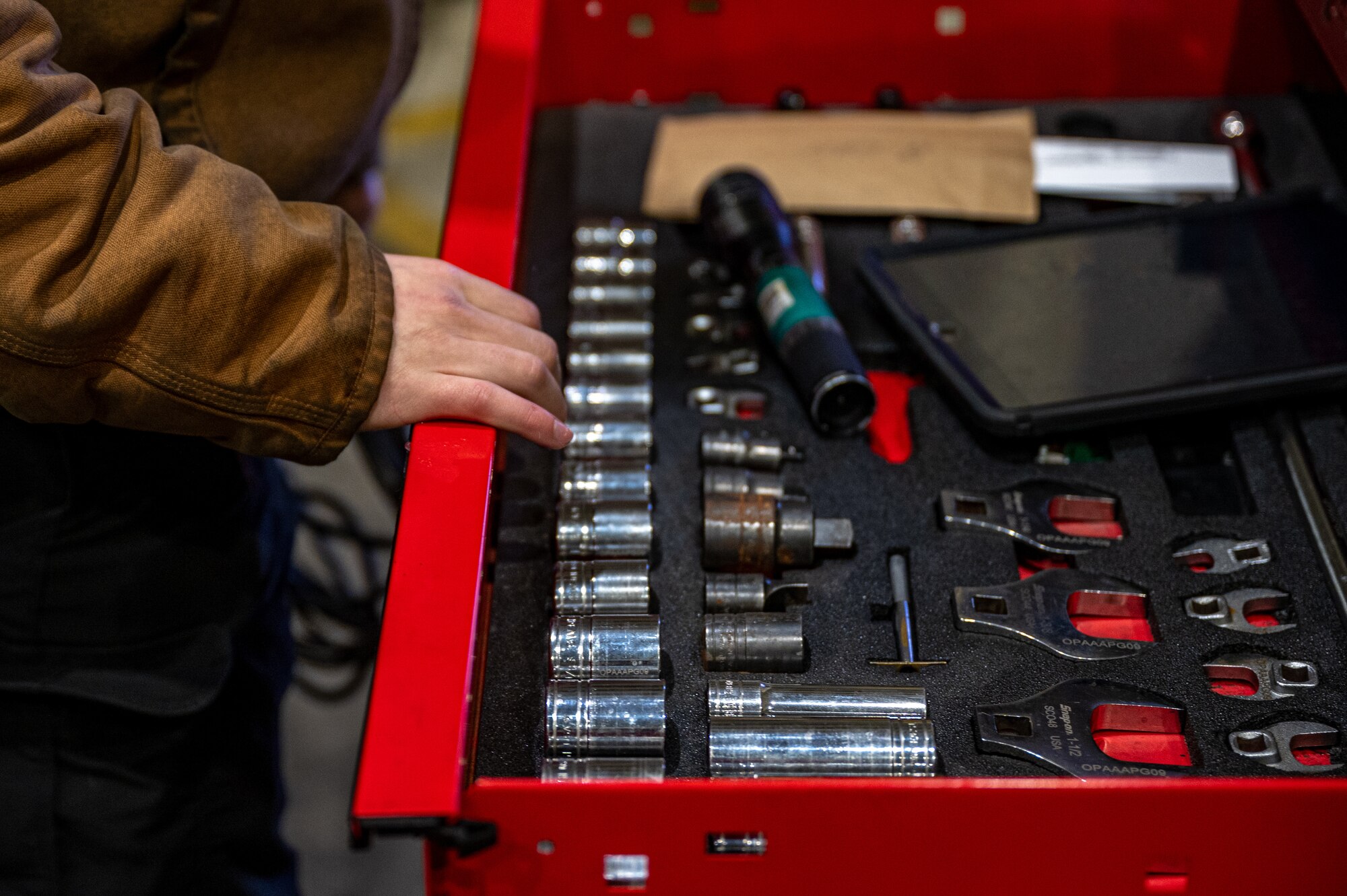 U.S. Air Force Airman 1st Class Tucker Arnold, 25th Fighter Generation Squadron crew chief, opens a toolbox drawer before a pre-flight inspection at Osan Air Base, Republic of Korea, Jan. 22, 2024. Proper composite tool kit inventories are essential to maintain because a misplaced tool could end up being drawn into the engine and damage the aircraft. The APG section ensures aircraft are fully mission capable and ready to “Fight Tonight”. (U.S. Air Force photo by Airman 1st Class Chase Verzaal)