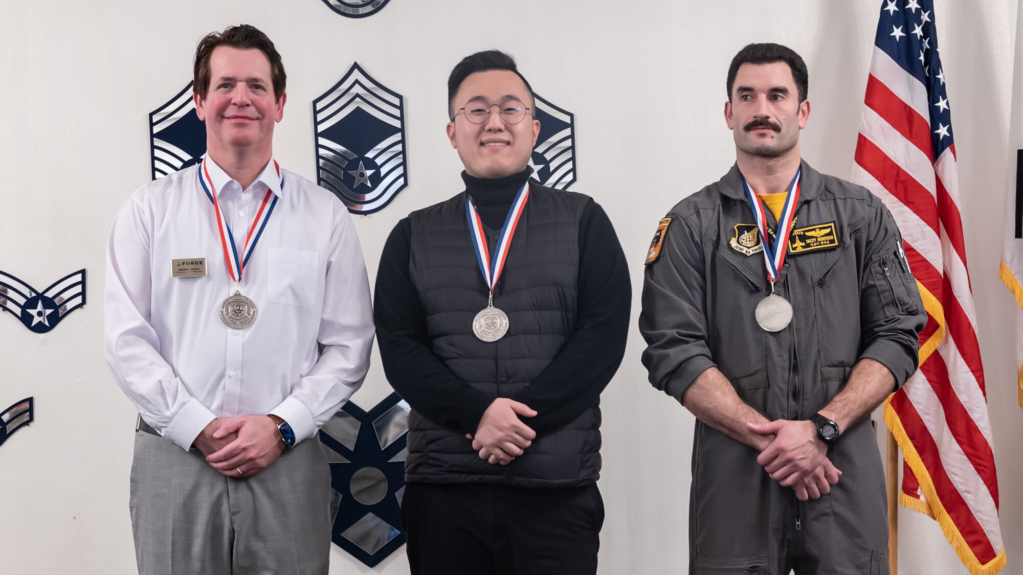 From left, Donnie Parish, Jongyou Kim and Maj Rex Anderson pose for a group photo after winning their respective categories during the 7th Air Force 2023 annual awards