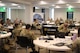 group of people wearing u.s. army uniforms sit in groups in an office.