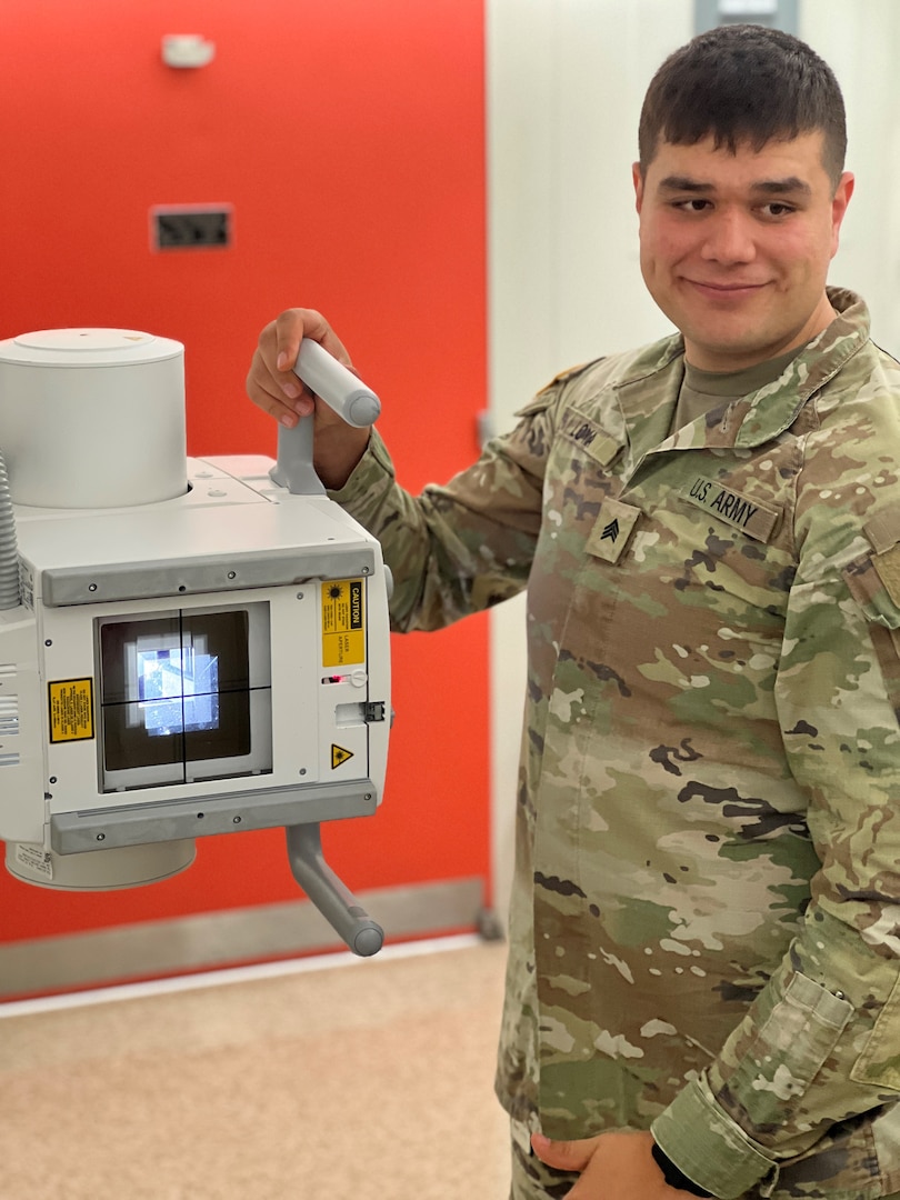 Smiling Soldier standing in front of X-ray apparatus,