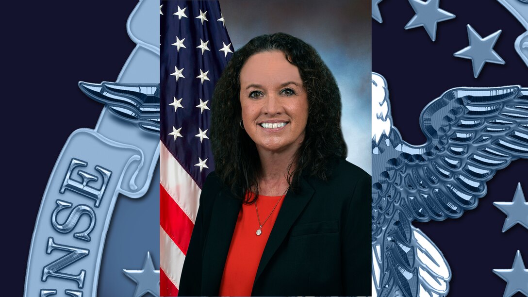 A woman standing in front of the American flag.
