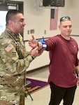 Two Soldier demonstrating medical procedures for a crowd of 4-H members.