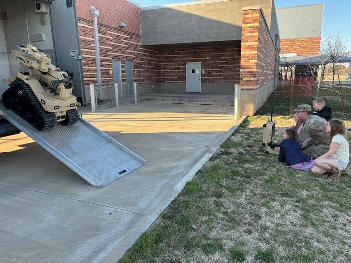 An Airman unloading a robot from a trailer