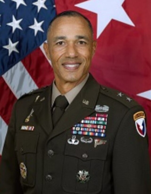 A dark skinned man in a green Army dress uniform.