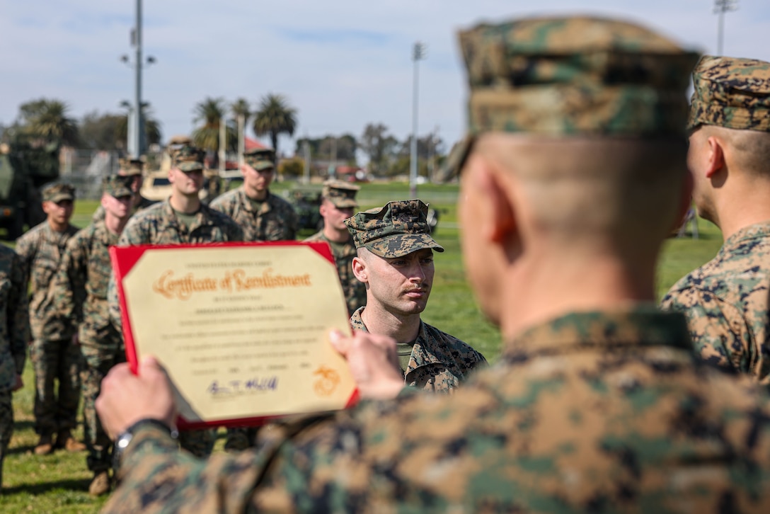 U.S. Marine Corps Sgt. Nate Bullock, a rifleman with 3rd Battalion, 5th Marine Regiment, 1st Marine Division, stands at attention while Sgt. Maj. Carlos Ruiz, the sergeant major of the Marine Corps, reads his certificate of reenlistment during a ceremony at Marine Corps Base Camp Pendleton, California, Feb. 16, 2024. Ruiz mentioned Bullock’s name during an informational video about the commandant’s retention program, which was a contributing factor in Bullock deciding to reenlist. Bullock is awaiting orders to be a recruiter in his home state of Arizona as part of his reenlistment. (U.S. Marine Corps photo by Cpl. Juan Torres)