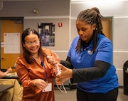 Community Outreach and Student Engagement Coordinator Ashlee Floyd guides a Department of Defense STEM Ambassador through a STEM-In-a-Box activity