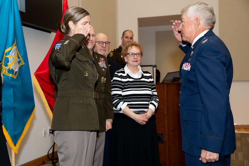 U.S. Army Reserve Brig. Gen. Melissa Adamski (left), commander, Military Intelligence Readiness Command, receives a salute from her uncle, retired U.S. Air Force Col. Ted Hilbun (right), during her promotion ceremony.