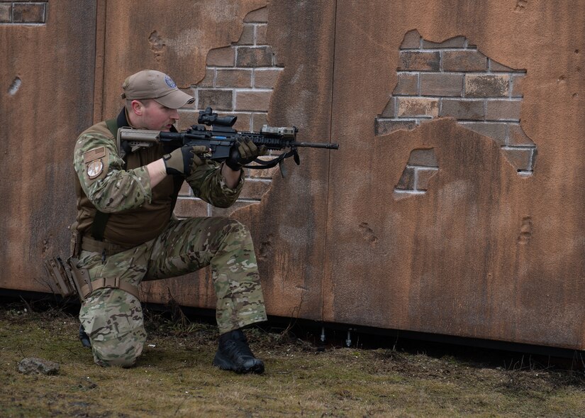 A guardsman kneels while aiming a weapon.