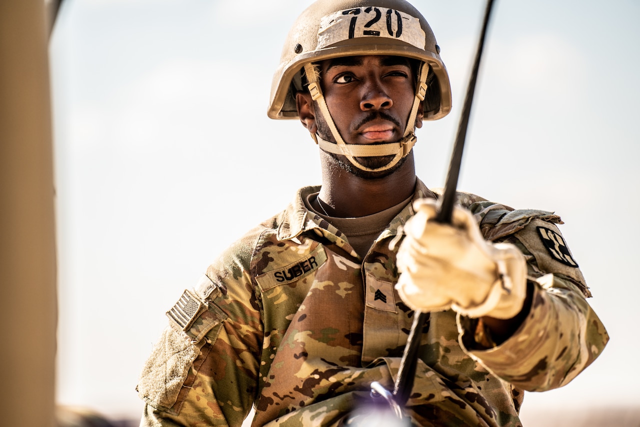 A close-up of a soldier rappelling.