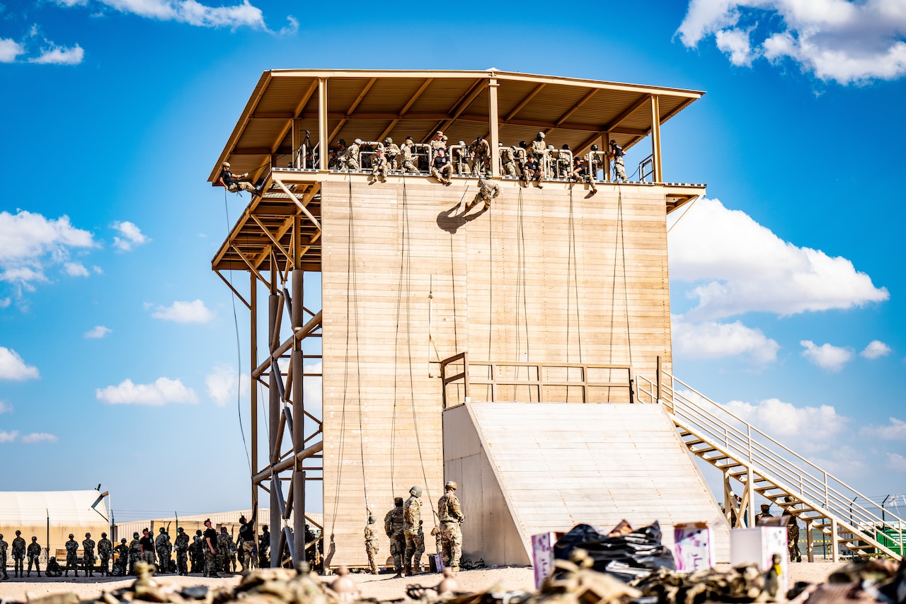Soldiers rappel off a tower.