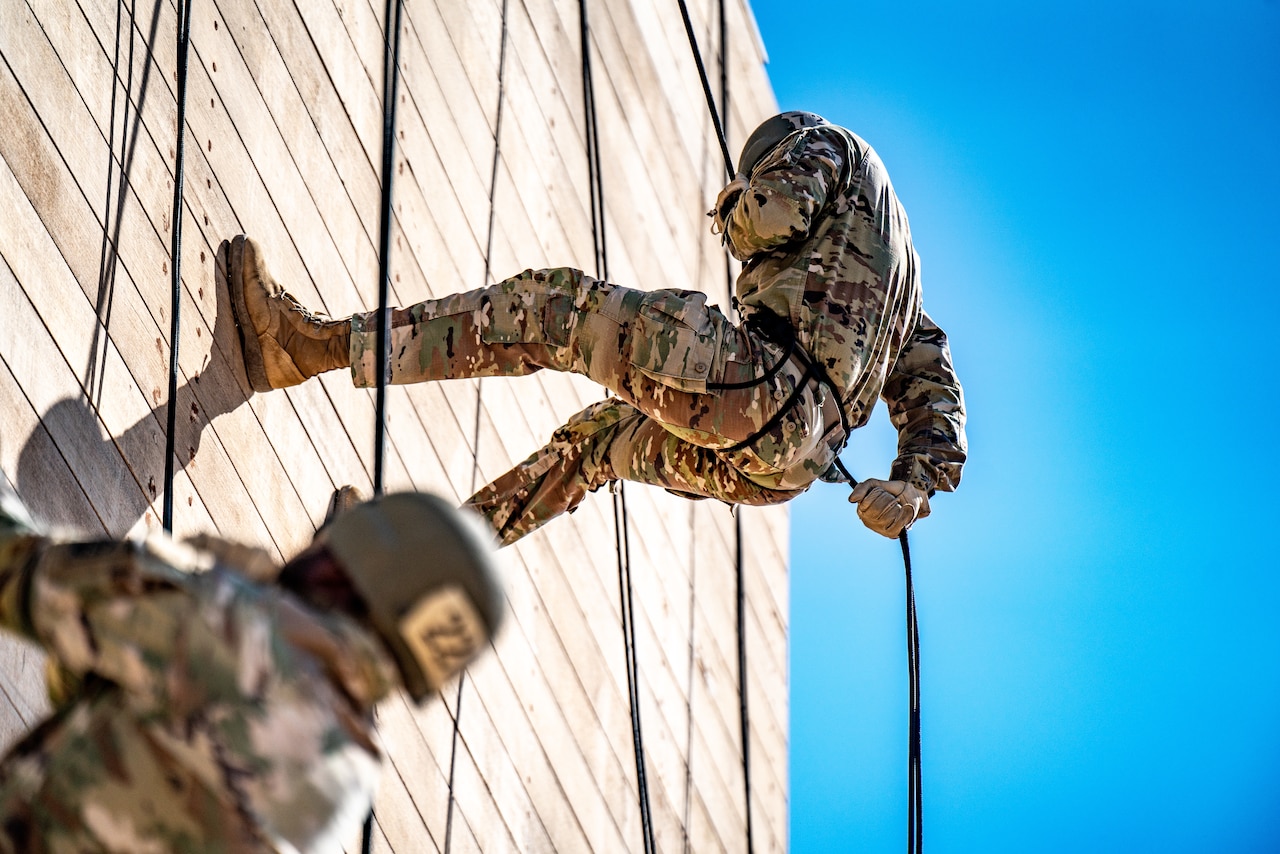 Soldiers rappel off towers.
