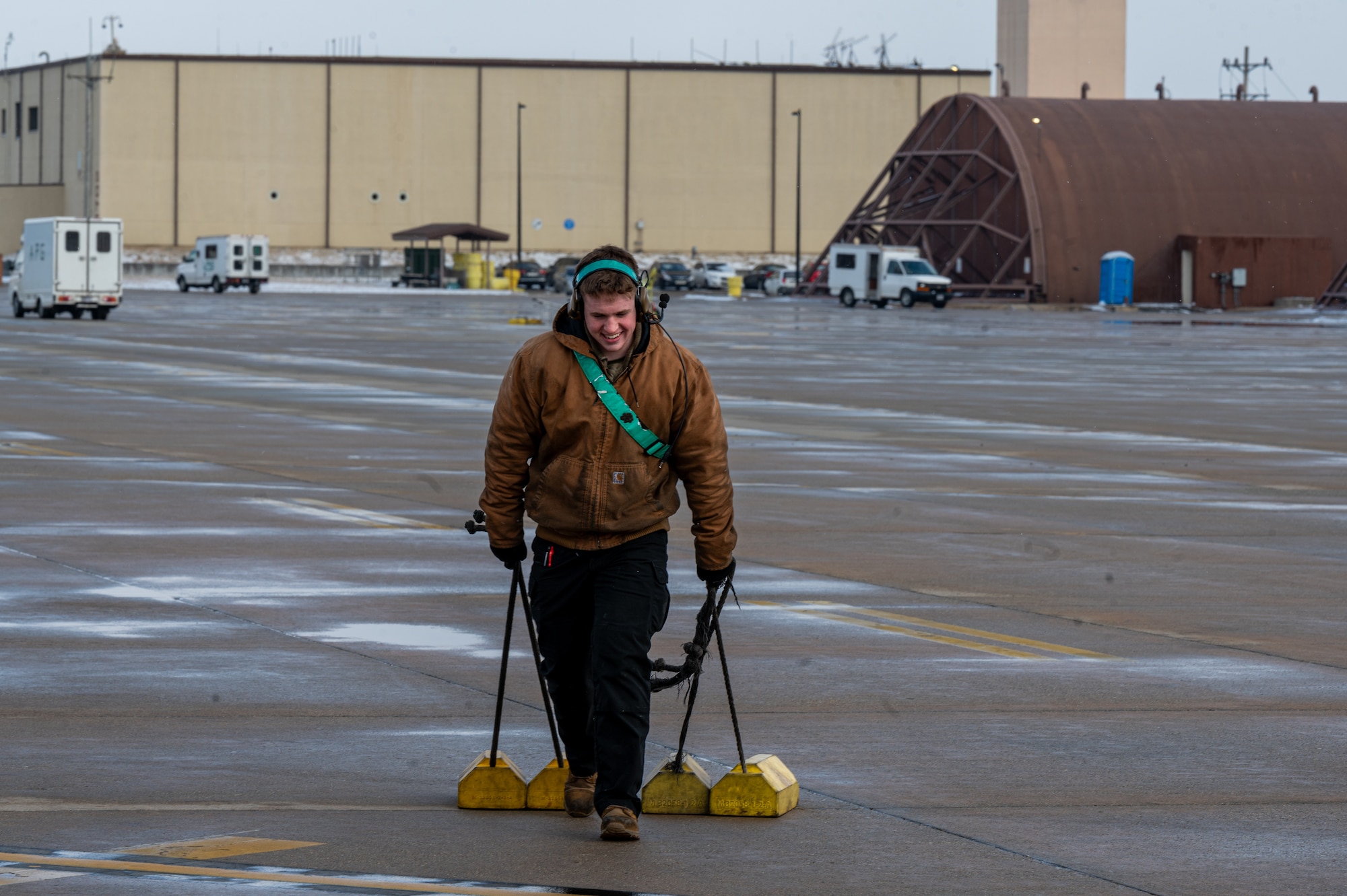 U.S. Air Force Airman 1st Class Tucker Arnold, 25th Fighter Generation Squadron crew chief, drags chocks out of the taxiway at Osan Air Base, Republic of Korea, Jan. 22, 2024. Crew chiefs fall under the airframe, powerplant and general flight, which prioritize the safety of the pilots and the aircraft. Airmen from APG have the authority to prevent aircraft from taking off in the event that they are unable to make the aircraft fully mission capable by the time they are scheduled to fly. (U.S. Air Force photo by Airman 1st Class Chase Verzaal)