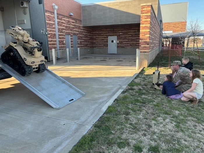 An Airman unloading a robot from a trailer