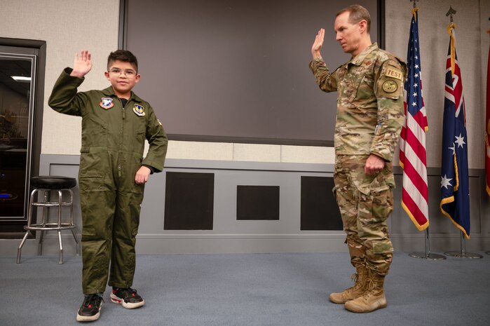 Col. Douglas Wickert, 412th Test Wing commander, "commissions" Dean Lomelin during his visit to Edwards Air Force Base, California, Jan. 31, 2024.