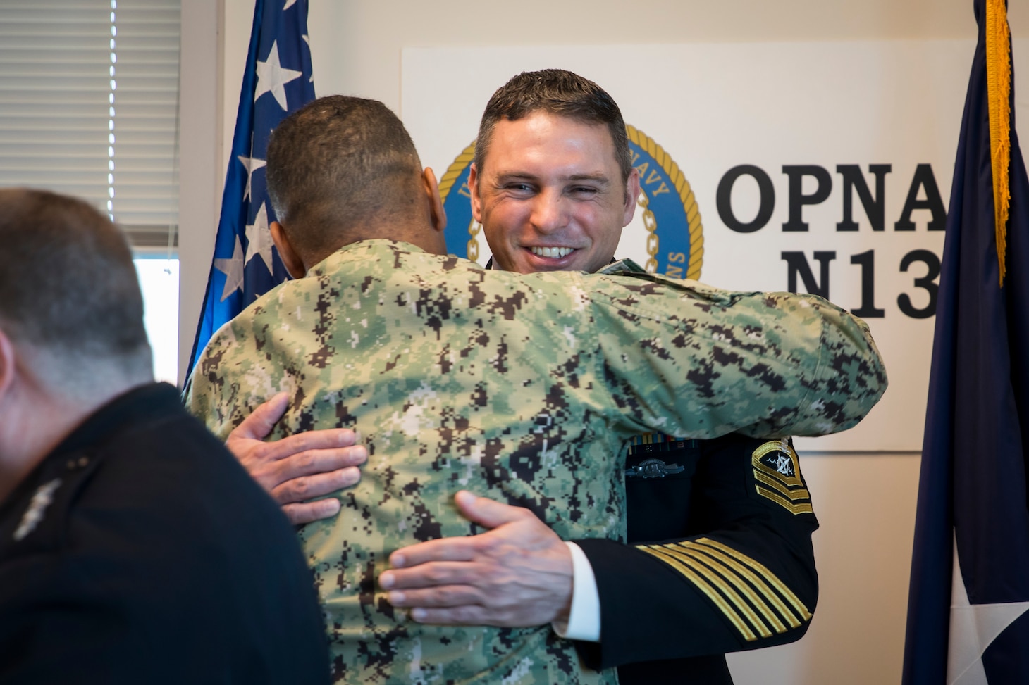 Navy Master Chief Petty Officer wears service dress blues in the Navy's N13 office, highlighting the Robotics Warfare Specialist rating badge