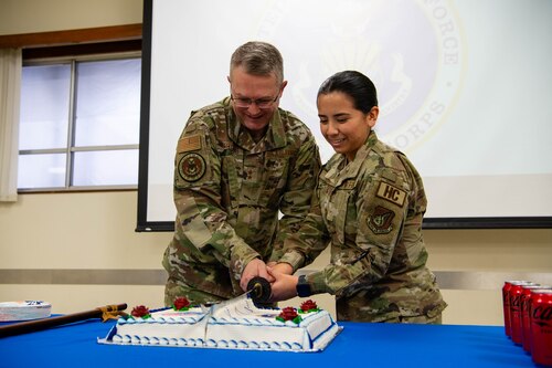 U.S. Air Force Chaplain Maj. Gen. Randall Kitchens, U.S. Air Force chief of chaplains, and Airman Sophia Romero, 374th Airlift Wing religious affairs apprentice, cut a cake with a samurai sword to celebrate the 75th anniversary of the Chaplain Corps at Yokota Air Base, Japan.