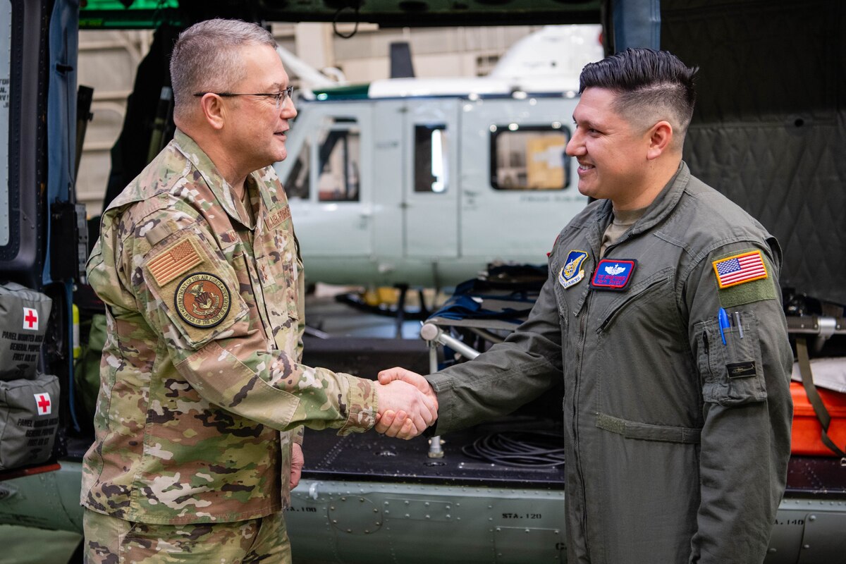 U.S. Air Force Chaplain Maj. Gen. Randall Kitchens, U.S. Air Force chief of chaplains, coins Tech. Sgt. Jeovany Vasquez, 459th Airlift Squadron non-commissioned officer in charge of tactics, at Yokota Air Base, Japan.