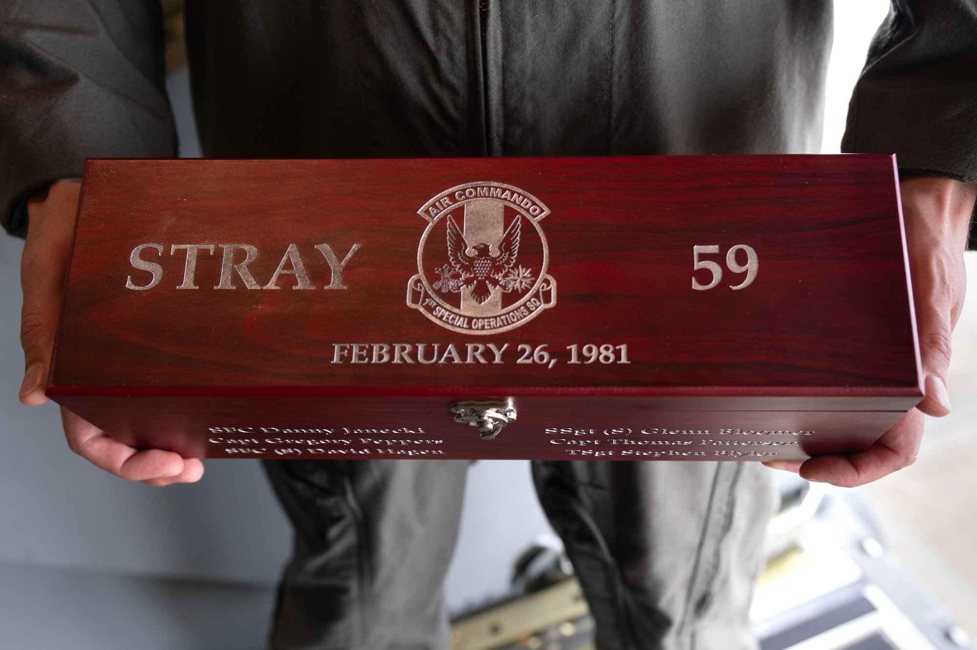 Airman holds a STRAY 59 memorial box