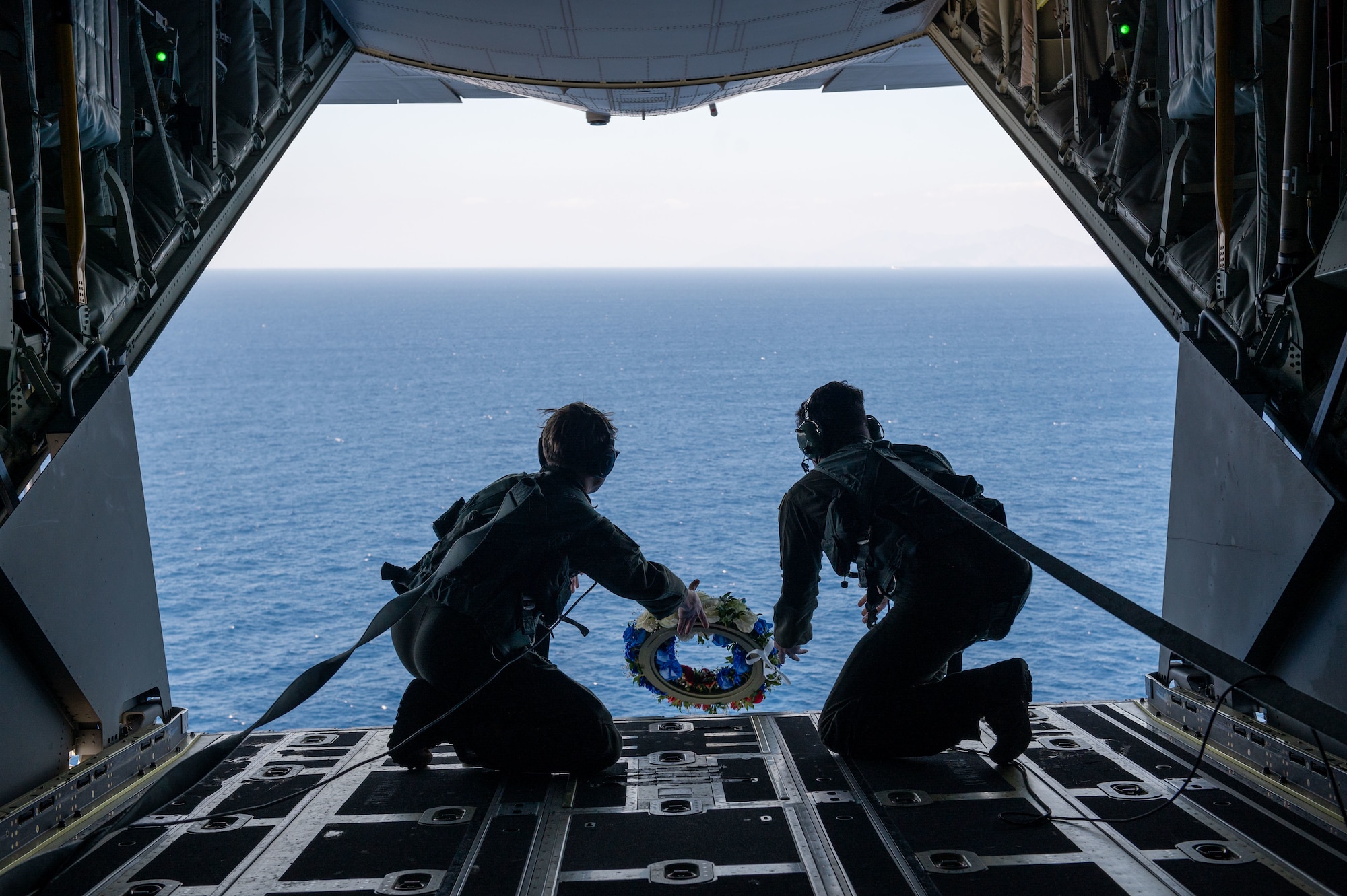U.S. Air Force loadmasters assigned to the 1st Special Operations Squadron airdrop a memorial wreath over the coast of the Philippines