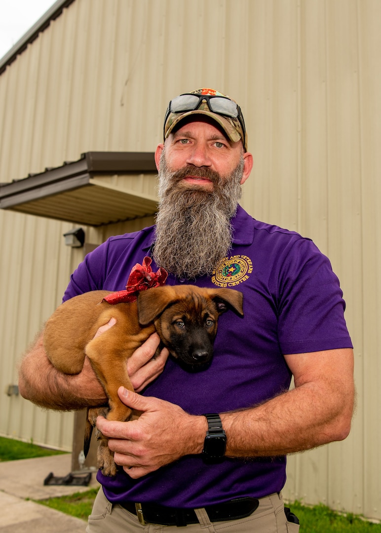 Keith Williams holds six-week-old pup RRuin at Joint Base San Antonio-Lackland, Texas, Feb. 14, 2024. Williams is fostering the pup through the Department of Defense’s Military Working Dog Puppy Foster Volunteer Program. Williams was inspired to foster a MWD after the loss of the family’s pet and an even greater desire to contribute to a program he knew to have saved lives. Williams, now retired, served alongside the MWDs during a deployment to Afghanistan. (U.S. Photo by Vanessa R. Adame)