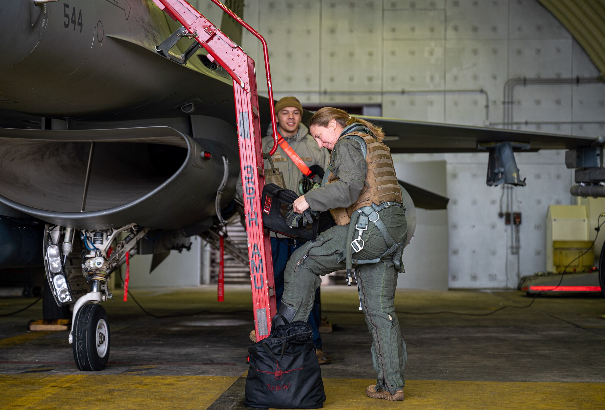A pilot gets into an F-16 cockpit.