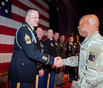 Senior Enlisted Advisor Tony Whitehead, senior enlisted advisor to the chief of the National Guard Bureau, congratulates Sgt. Maj. Tyson Bumgardner, a graduate of class 001-24 of the Sergeants Major Academy's distance learning course, during a ceremony at Fort Bliss, Texas, Feb. 23, 2024. Whitehead addressed the distance learning graduates and participants of the 10-month resident course.