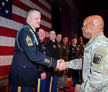 Senior Enlisted Advisor Tony Whitehead, senior enlisted advisor to the chief of the National Guard Bureau, congratulates Sgt. Maj. Tyson Bumgardner, a graduate of class 001-24 of the Sergeants Major Academy's distance learning course, during a ceremony at Fort Bliss, Texas, Feb. 23, 2024. Whitehead addressed the distance learning graduates and participants of the 10-month resident course.