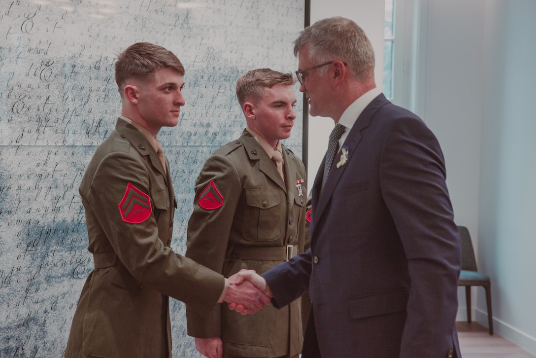 U.S. Marine Corps Cpl. Aiden Morey, a rifleman with 2d Light Armored Reconnaissance Battalion, 2d Marine Division and an Arizona native, shakes hands with the Estonian Ambassador to the United States Mr. Kristian Prikk during an award ceremony in Washington D.C., Feb. 23, 2024. The Marines were awarded with the Estonian Rescue Board Lifesaving Medal from the Estonian Ambassador to the United States for heroic actions by rendering medical assistance to an injured Estonian civilian. (U.S. Marine Corps photo by Cpl. Max Arellano)