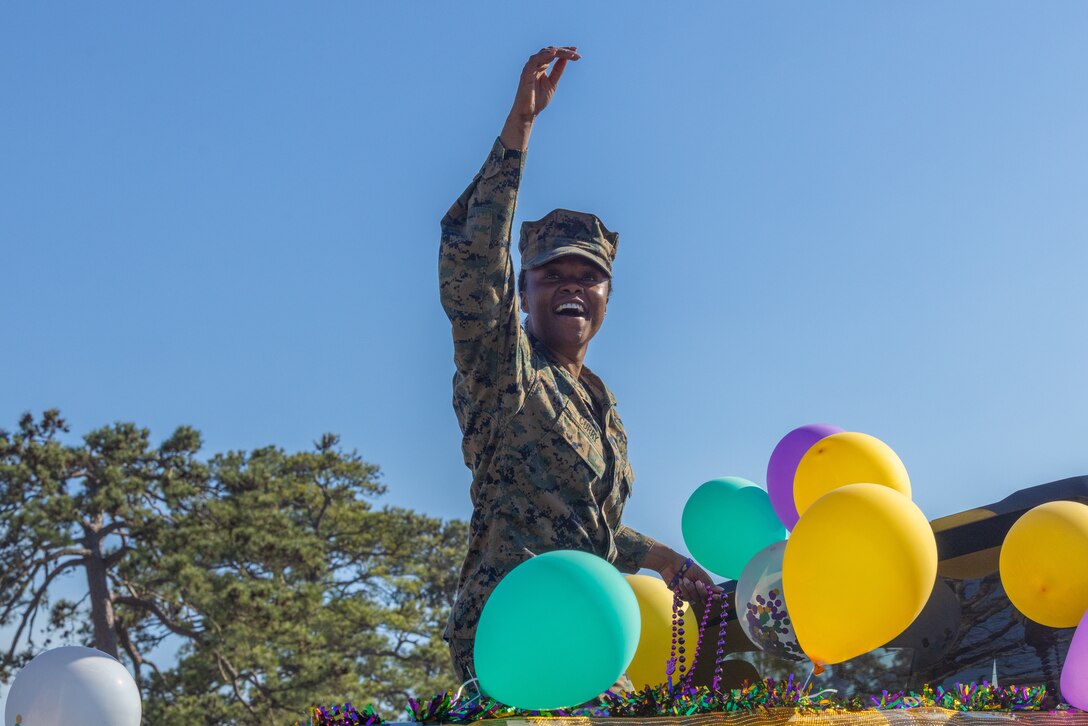 U.S. Marine Corps 1st Lt. Dominee Curry, a maintenance management officer with 2d Battalion, 10th Marine regiment, 2d Marine Division, passes out beads to audience members during a Mardi Gras parade on Camp Lejeune, North Carolina, Feb. 21, 2024. The 10th Marine Regiment participated in the first Mardi Gras parade on Camp Lejeune to help build a sense of community between Marines and their families. (U.S. Marine Corps photo by Lance Cpl. Daysia McCree)