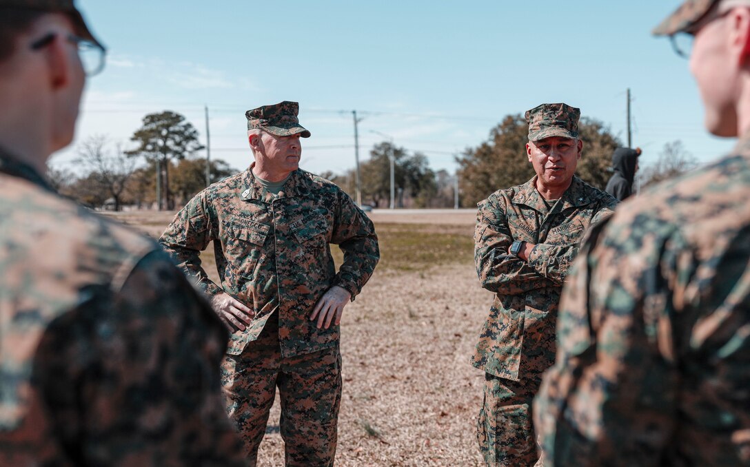 U.S. Marine Corps Sgt. Maj. Ryan Gnecco, left, the sergeant major of  Marine Corps Installation East and Brig. Gen. Adolfo Garcia Jr., right, the commanding general of Marine Corps Installation East, speak with Marines during a Presidents Day celebration on Camp Lejeune, North Carolina Feb. 19, 2024. The 21 Gun Salute, held in honor of Presidents Day in accordance with Naval Regulations, in which each saluting ship, naval station and installation having a saluting battery shall fire a national salute of 21- guns. (U.S. Marine Corps photo illustration by Cpl. Megan Ozaki)