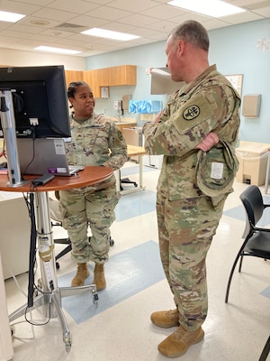 Army Medical Command East Command Sergeant Major Alexander Poutou, right, speaks with Sgt. Ashtin Josey in the Occupational Health clinic during a visit to Guthrie Ambulatory Health Care Clinic at Fort Drum, New York. Poutou met with leaders and visited members of the Army Medical Department Activity (MEDDAC) Fort Drum and leaders of the 10th Mountain Division.