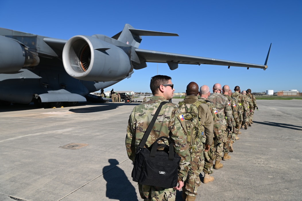 Texas State Guardsmen approach a C-17 Globemaster single file in preparation for joint medical training with the 433rd Aeromedical Evacuation Squadron at Joint Base San Antonio-Lackland, Texas on Feb. 24, 2024.