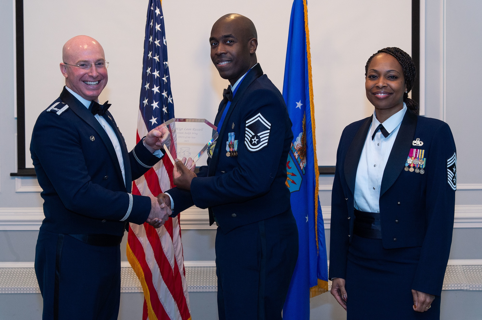U.S. Air Force Col. Chris McDonald, left, 436th Airlift Wing commander, and U.S. Air Force Chief Master Sgt. Carolyn Russell, right, 436th AW command chief, present U.S. Air Force Senior Master Sgt. Leon Russell, center, 436th Medical Group annual award winner, with a trophy during the 2023 436th AW Annual Awards Ceremony held at the Hartly Volunteer Fire Company in Hartly, Delaware, Feb. 23, 2024. Russell was recognized as the wing’s Senior Noncommissioned Officer of the Year. (U.S. Air Force photo by Roland Balik)