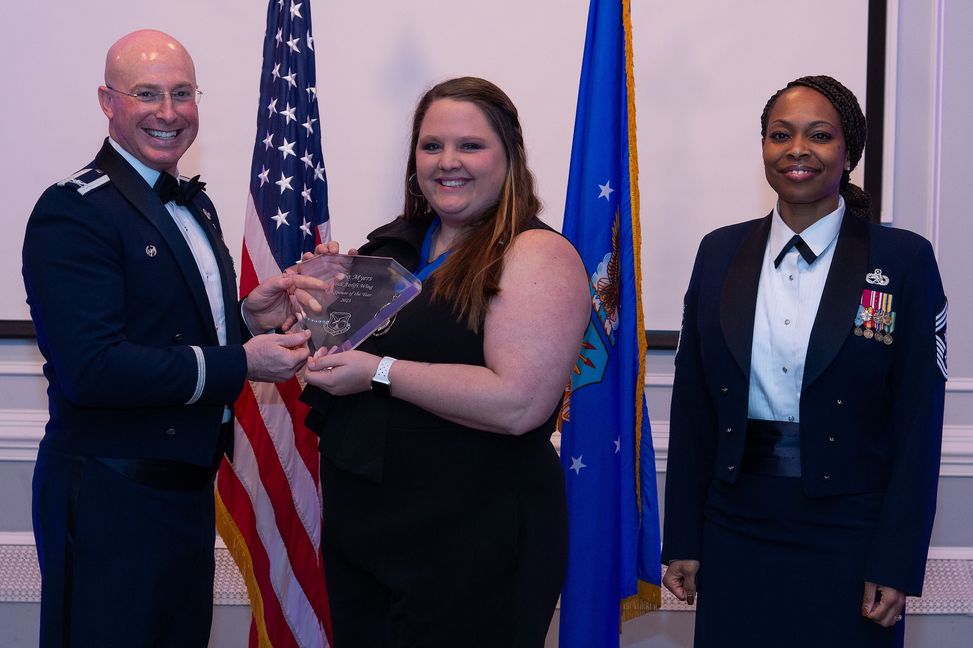 U.S. Air Force Col. Chris McDonald, left, 436th Airlift Wing commander, and U.S. Air Force Chief Master Sgt. Carolyn Russell, right, 436th AW command chief, present Reba Myers, center, 436th Operations Group annual award winner, with a trophy during the 2023 436th AW Annual Awards Ceremony held at the Hartly Volunteer Fire Company in Hartly, Delaware, Feb. 23, 2024. Myers was recognized as the wing’s Key Spouse of the Year. (U.S. Air Force photo by Roland Balik)