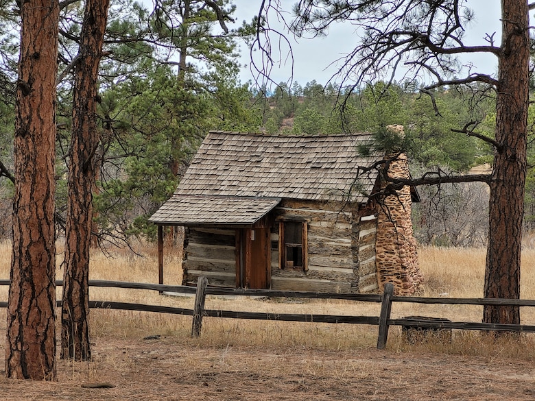 The Burgess-Capps Cabin, located on the U.S. Air Force Academy, Colorado, was constructed in 1875. It is made of hewn log walls chinked with mortar, and inside there is a loft with an enclosed stairway, a stone fireplace and a chimney.