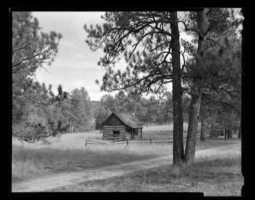 The Burgess-Capps Cabin, located on the U.S. Air Force Academy, Colorado, was constructed in 1875. It is made of hewn log walls chinked with mortar, and inside there is a loft with an enclosed stairway, a stone fireplace and a chimney.