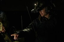 Airman points to battle management tool at night