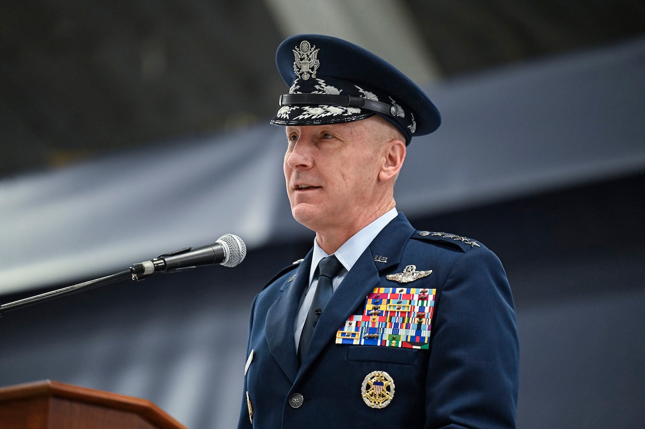 A person in uniform stands at a lectern.